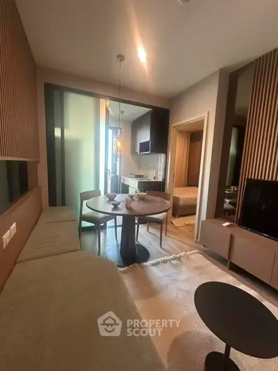 Modern living room with cozy dining area and open kitchen in stylish apartment.