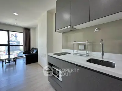 Modern open-layout kitchen with sleek cabinetry and integrated appliances in a stylish apartment.