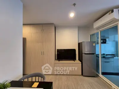 Modern apartment interior with sleek kitchen and stylish living area, featuring built-in storage and air conditioning.