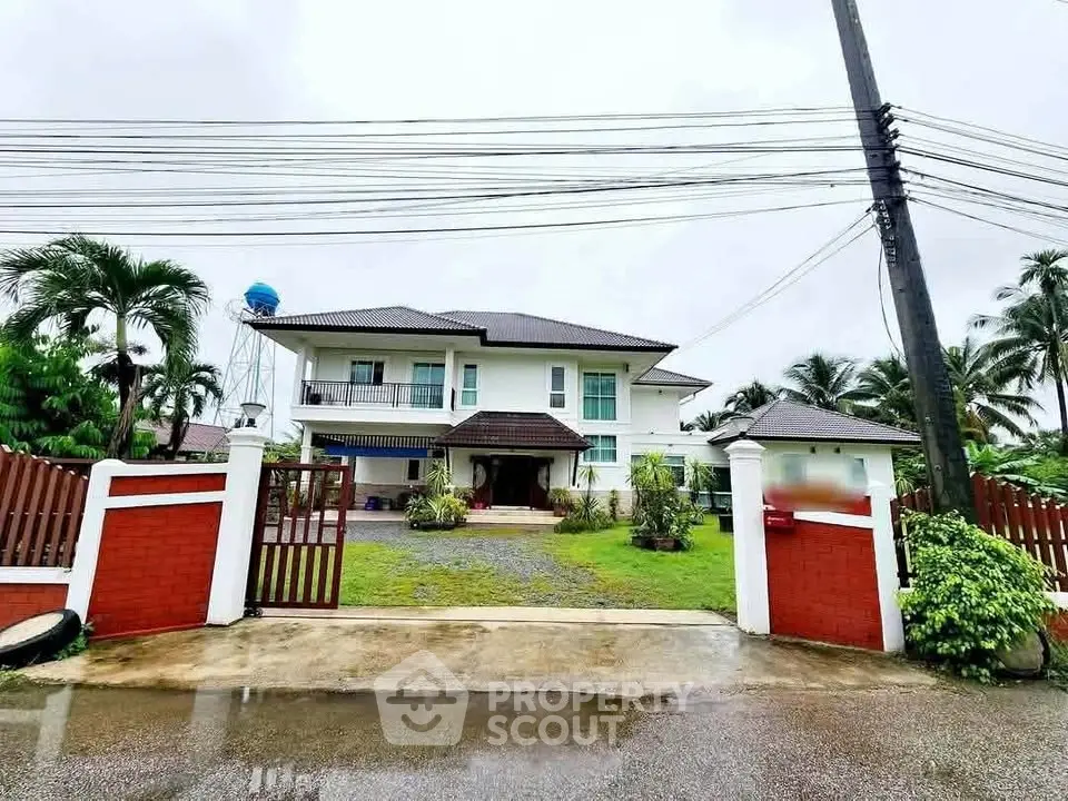 Stunning two-story house with lush garden and gated entrance, perfect for family living.