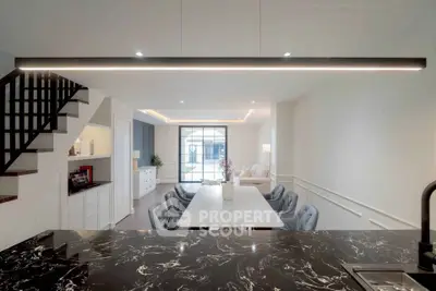 Modern open-plan living room with elegant marble countertop and stylish dining area