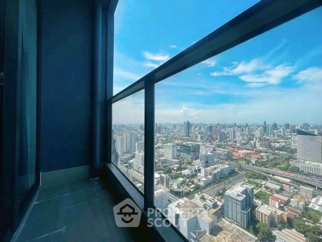 Stunning high-rise balcony view overlooking the city skyline with clear blue skies.