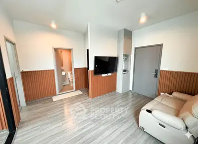 Modern living room with sleek flooring and wall-mounted TV