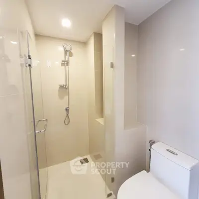 Modern bathroom with sleek shower and neutral tiles in a contemporary apartment.