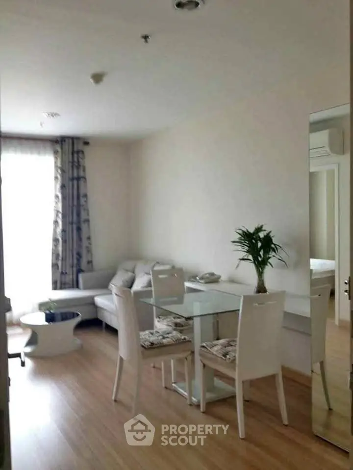 Modern living room with elegant dining area and cozy seating, featuring natural light and stylish decor.
