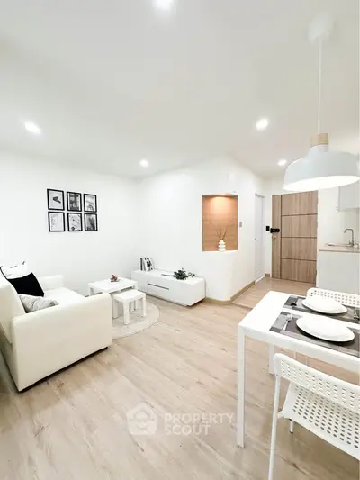 Modern living room with white decor and open kitchen layout