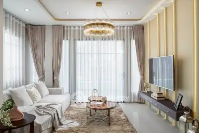 Luxurious living room with elegant decor, plush rug, and modern chandelier, perfect for stylish living.