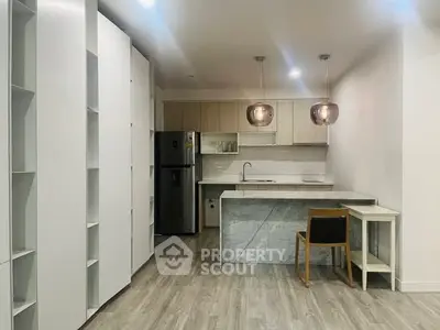 Modern kitchen with sleek cabinetry and stylish pendant lights in open layout