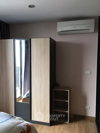 Modern bedroom with sleek wardrobe and air conditioning unit, perfect for comfort and style.