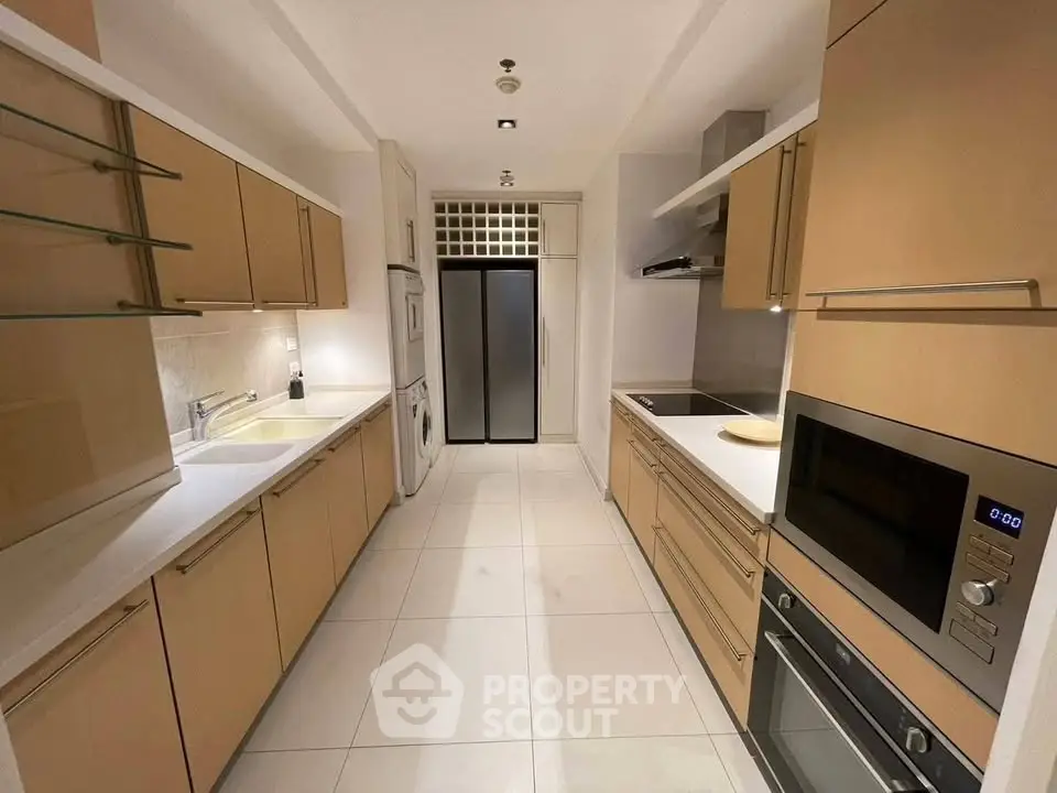 Modern kitchen with sleek cabinetry, built-in appliances, and spacious countertops in a stylish apartment.