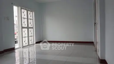 Spacious empty room with glossy tiled floor and large window
