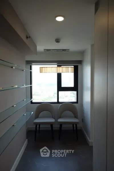 Modern interior with sleek shelving and seating, featuring a large window with city view.