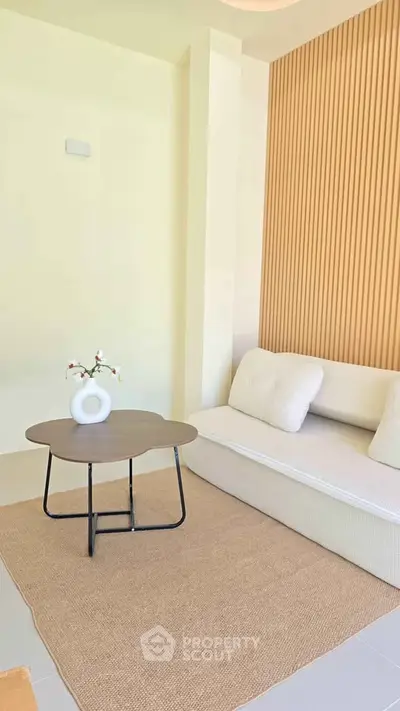 Modern minimalist living room with stylish sofa and coffee table, featuring elegant wooden wall paneling.