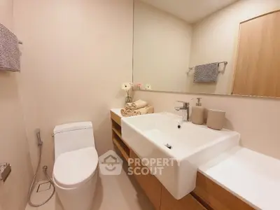 Modern bathroom with sleek fixtures and large mirror in a minimalist design.