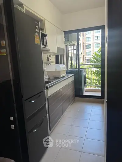 Modern kitchen with sleek cabinets and balcony view in urban apartment
