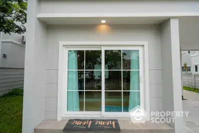 Modern home entrance with sliding glass door and welcome mat