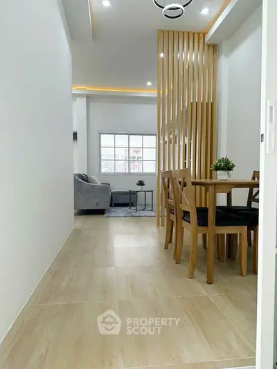 Modern open-plan dining area with wooden accents and cozy living space, perfect for contemporary living.