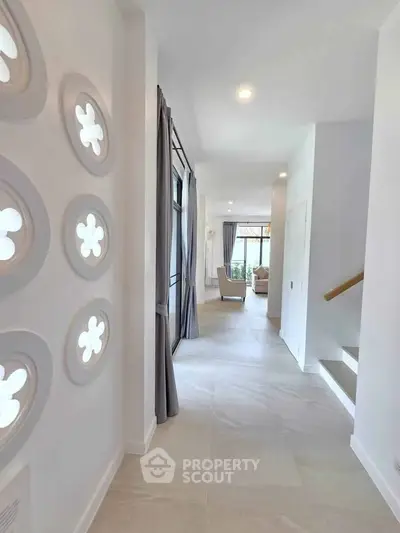 Elegant hallway with modern decor leading to a bright living area in a stylish home.