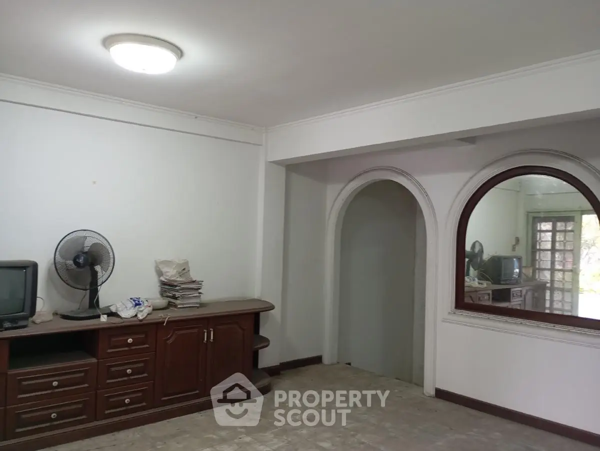 Spacious living room with classic wooden furniture and arched doorway