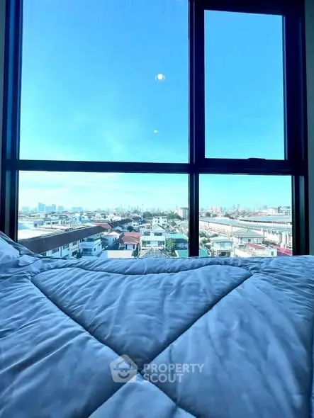 Stunning bedroom view with expansive cityscape through large window.