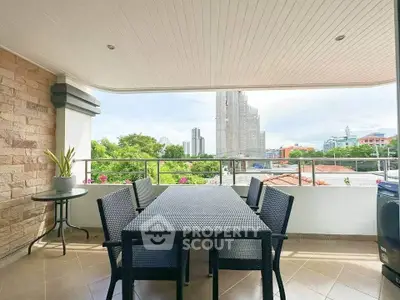 Spacious balcony with outdoor dining set and city view, perfect for relaxation and entertaining.