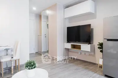 Modern living room with sleek TV setup and stylish furniture in a contemporary apartment.