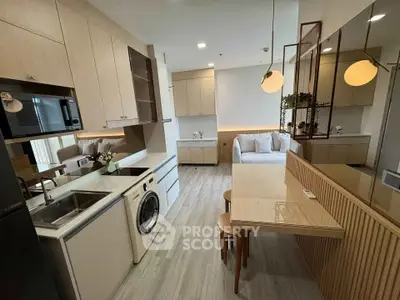 Modern open-layout kitchen and living area with sleek appliances and cozy seating.