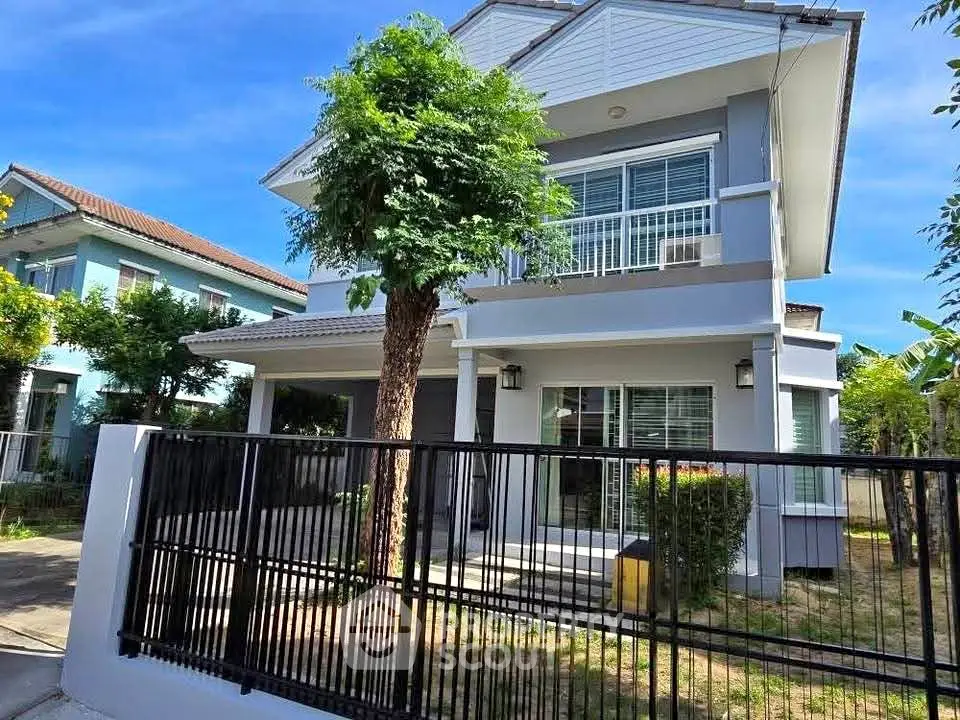 Charming two-story house with modern design and lush greenery in a serene neighborhood.