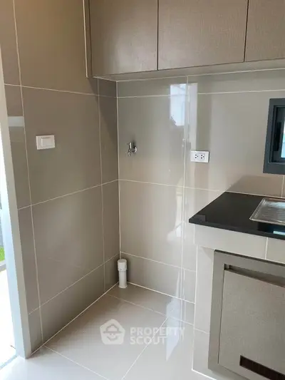 Modern kitchen corner with sleek cabinetry and glossy tiles