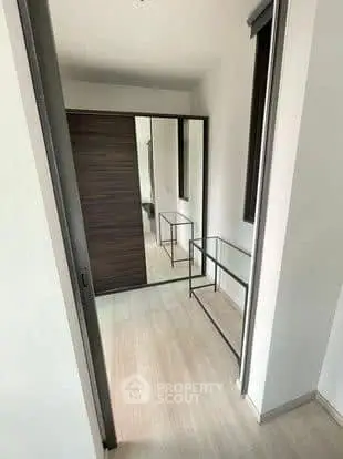 Modern minimalist hallway with sleek mirrored wardrobe and glass console table.