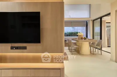 Modern open-plan living and dining area with sleek wooden finishes and large windows.