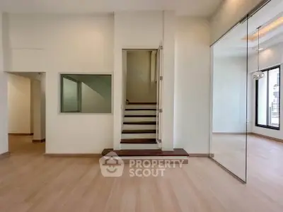 Spacious modern interior with wooden flooring and glass partition, ideal for open living concepts.