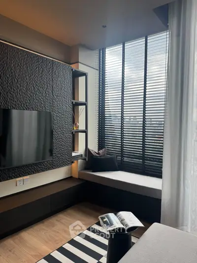 Modern living room with large window, stylish decor, and cozy seating area.