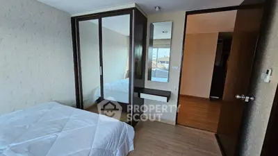 Cozy bedroom with mirrored wardrobe and wooden flooring in modern apartment