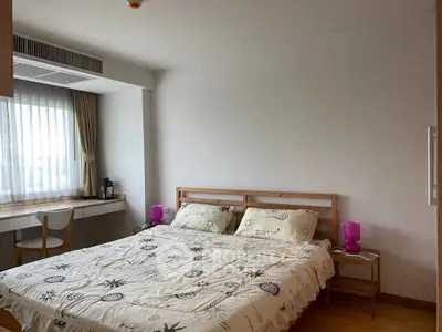 Cozy bedroom with large window and modern decor in a stylish apartment.