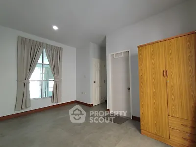 Spacious bedroom with natural light and wooden wardrobe