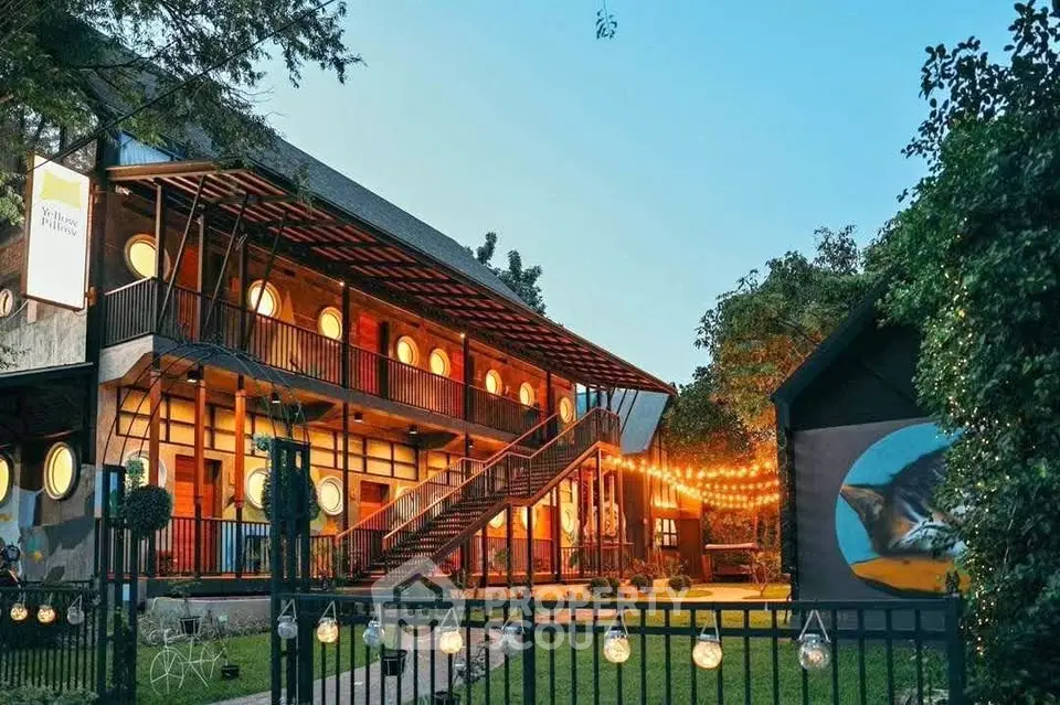 Charming modern building with unique circular windows and warm outdoor lighting, perfect for cozy evenings.