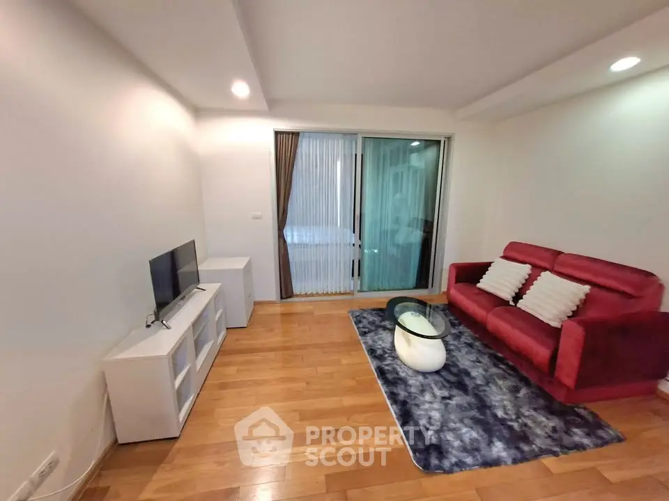 Modern living room with red sofa, TV, and stylish decor