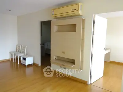 Spacious modern living room with wooden flooring and built-in air conditioning unit.