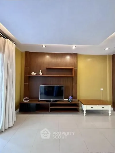 Spacious living room with modern TV setup and elegant decor