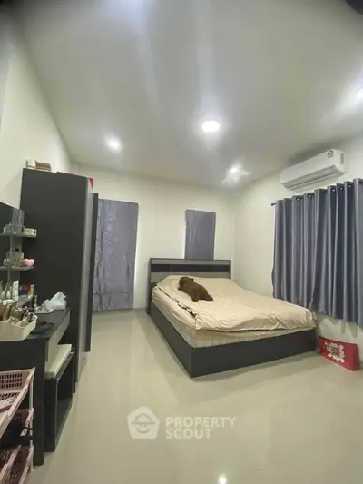 Spacious bedroom with modern furnishings and air conditioning, perfect for comfort and relaxation.