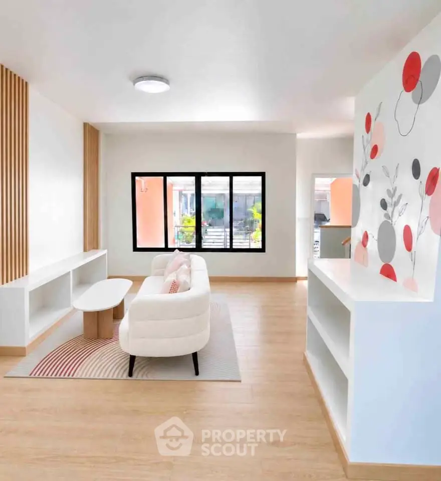 Modern living room with stylish decor and natural light, featuring a cozy sofa and elegant wall art.