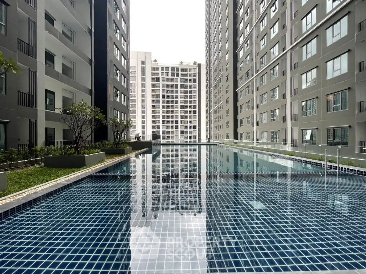 Modern apartment complex with a sleek swimming pool and high-rise buildings.