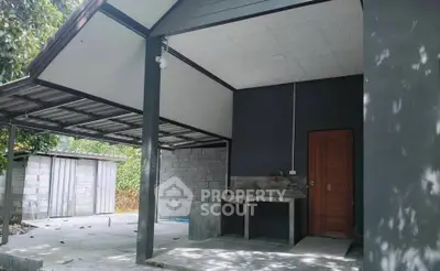 Modern outdoor space with covered area and concrete sink, ideal for versatile use.