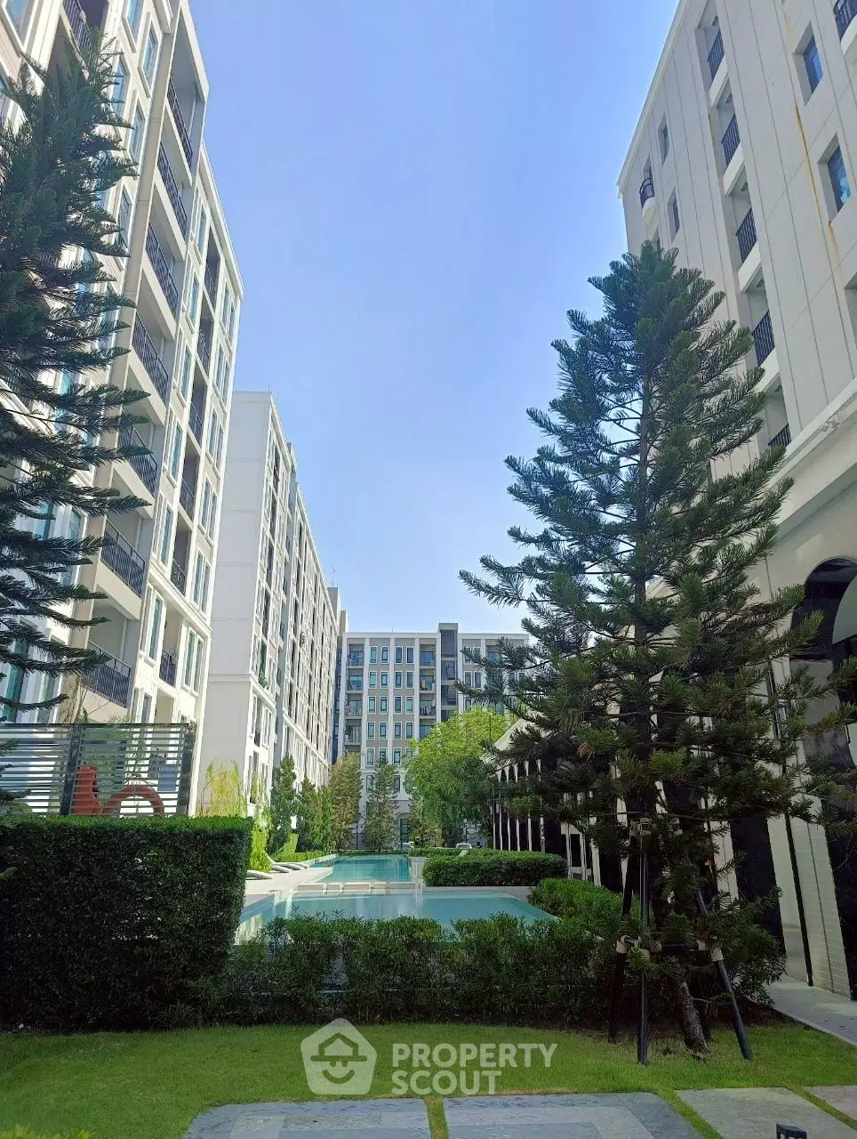 Modern apartment complex with lush greenery and pool view