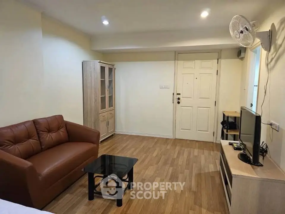 Cozy living room with modern furniture and wooden flooring in a stylish apartment.