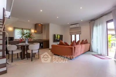 Spacious living room with modern decor and open kitchen layout, perfect for entertaining.