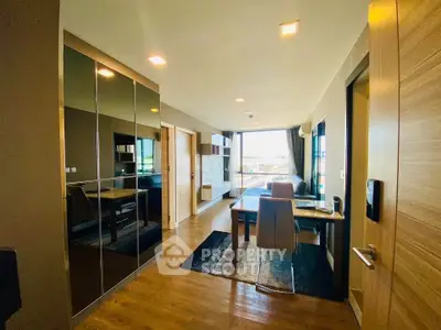 Modern living room with sleek design and ample natural light, featuring a dining area and stylish decor.