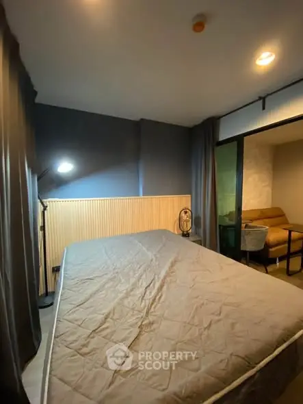 Cozy bedroom with modern lighting and adjacent seating area, perfect for relaxation.
