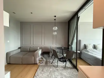 Modern living room with stylish furniture and adjacent bedroom in a contemporary apartment.
